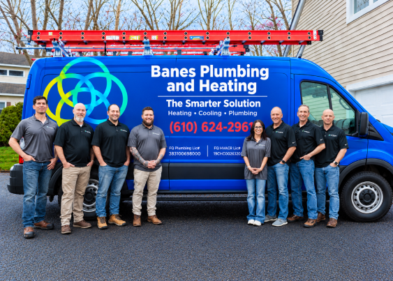 Eight Banes Plumbing and Heating employees standing in a row in front of a company van.
